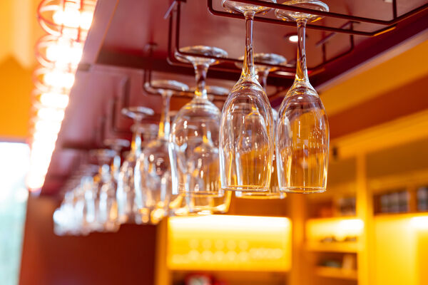 Champagne glasses hanging from bar shelf