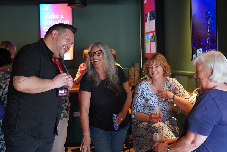 A man and three women talking and laughing