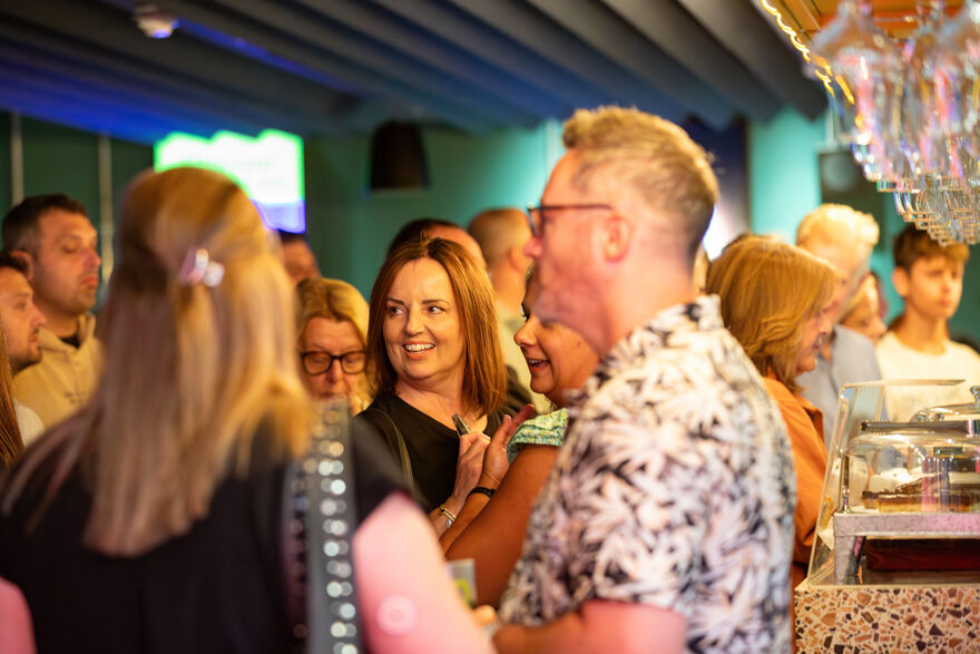 A crowd of people looking happy at the bar