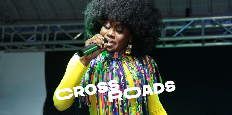 A female singer in brightly coloured dress with a microphone