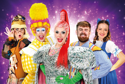 The cast of Beauty and the Beast at BEAM Hertford. Purple background with 5 characters wearing bright, colourful costumes.