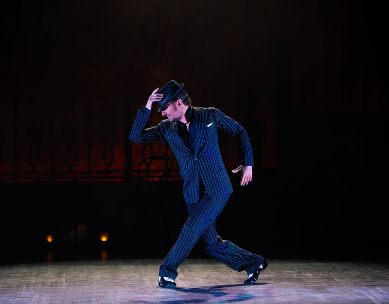 A male dancer in a pinstripe suit