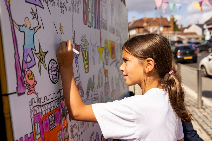 Girl drawing on canvas outdoors