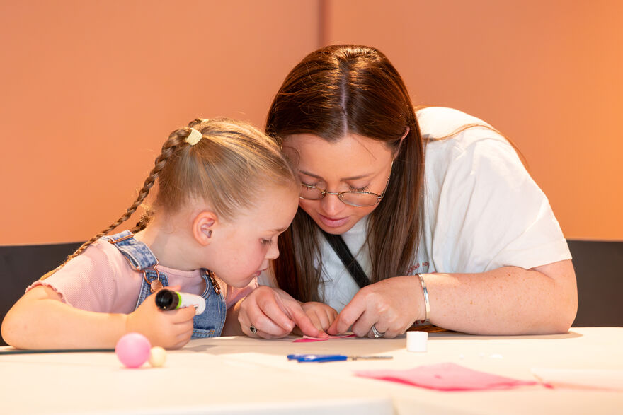 A woman and girl doing some craft