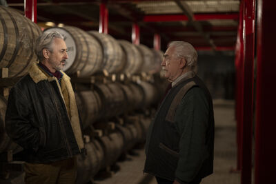 Two brothers standing in the middle of a whisky distillery