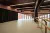 Dance studio with mirror wall and light coming through the window