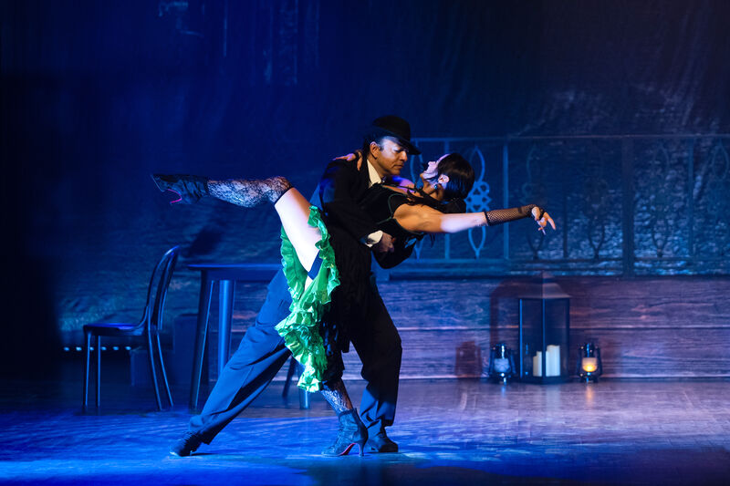 A man and a woman dance the tango in saloon costume