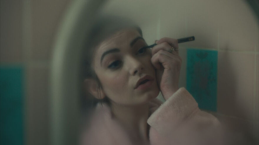 Effi putting on mascara in a misty mirror