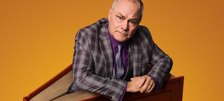 Comedian Jack Dee appears to be standing in the middle of an upright book.