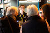 A woman in a BEAM t-shirt assisting three women at the bar 