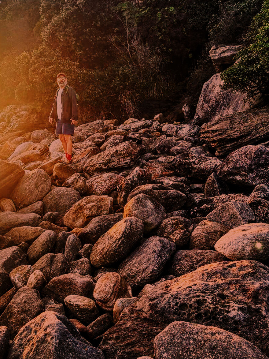 Man in hiking gear walking over boulders