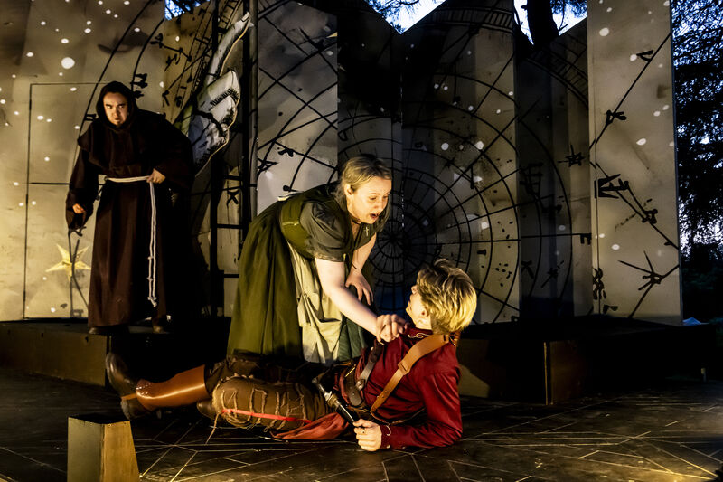 Three actors on stage depicting a scene from Romeo and Juliet