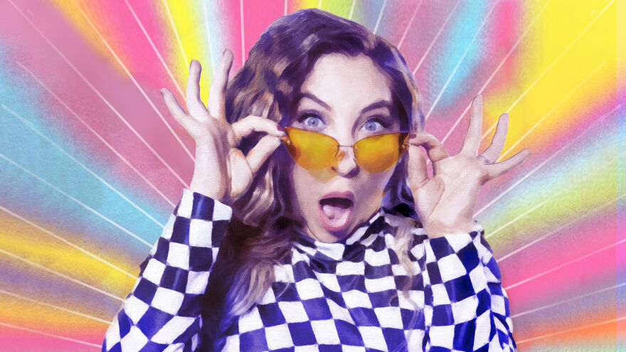 Jess Robinson wearing orange sunglasses and a purple and white chequered top with a vivid multicolour background